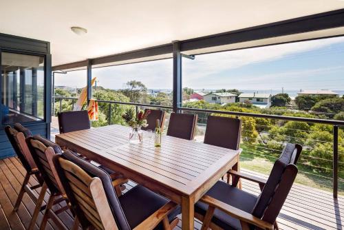 a dining room with a wooden table and chairs at Breakaway - Bay Views Games and Beach Bliss in Gracetown