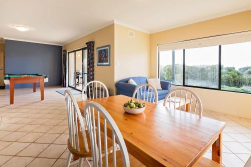 a dining room and living room with a table and chairs at Breakaway - Bay Views Games and Beach Bliss in Gracetown