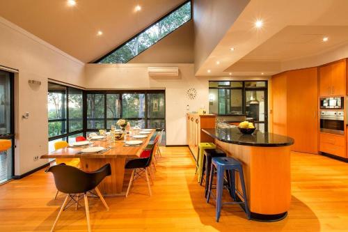 a kitchen with a large wooden table and chairs at Bringa - Spacious Bushland Retreat with Scenic Views in Yallingup