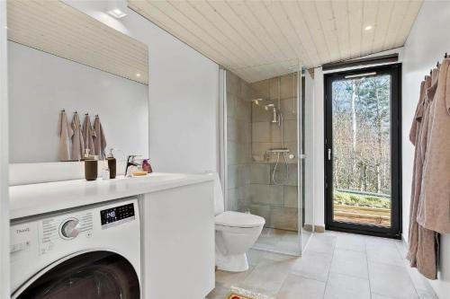 a bathroom with a washing machine and a toilet at 13380-Nykobing-Sj-Bag-Mollen-2 in Lumsås