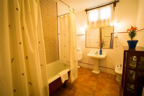 a bathroom with a tub and a toilet and a sink at Hospedería Real Casona la Beltraneja in Belmonte