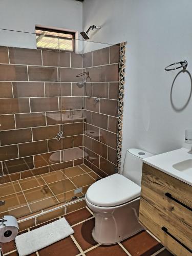 a bathroom with a shower with a toilet and a sink at Posada San Miguel in Orocué
