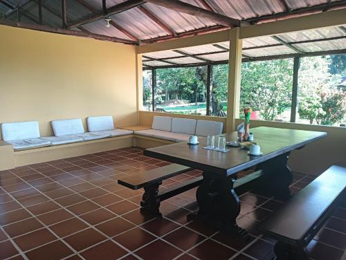 a dining room with a table and a bench at Posada San Miguel in Orocué