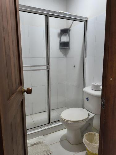 a bathroom with a toilet and a glass shower at Posada San Miguel in Orocué