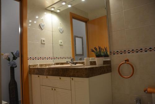 a bathroom with a sink and a mirror at Apartamento Flavia I Espalter in Sitges
