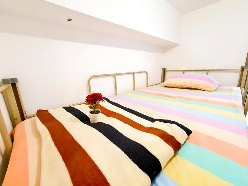 a bedroom with two beds and a flower in a vase at Apt SKY house 2br cozy & family in Cisauk 1