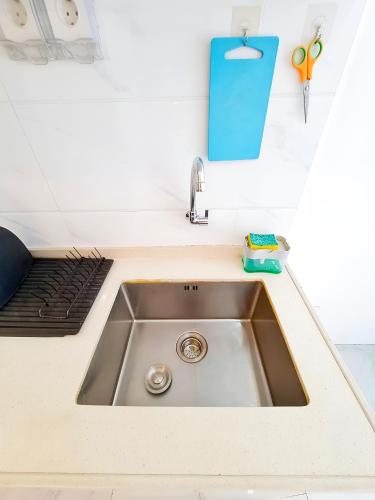 a kitchen counter with a sink and scissors and a clipboard at Apt SKY house 2br cozy & family in Cisauk 1