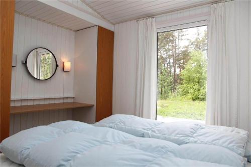 a bedroom with a bed and a mirror and a window at 0362-Romo-Skovskaden-17 in Mølby