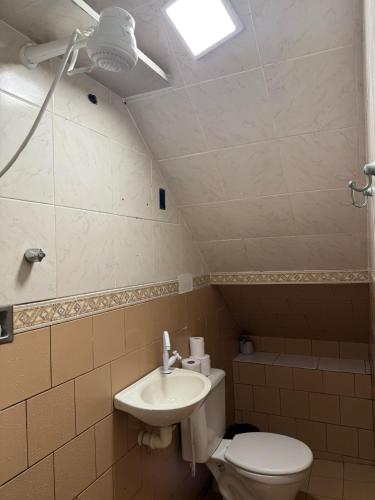 a bathroom with a toilet and a sink at Hospedagem no centro da cidade! in Macaé