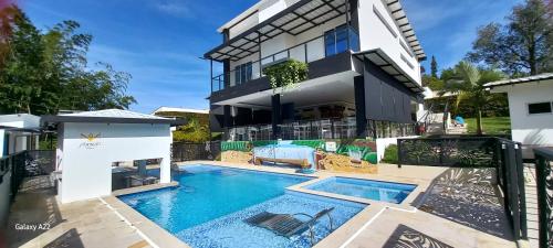 an image of a house with a swimming pool at Hotel y Cabañas Parinzzi in Guatapé