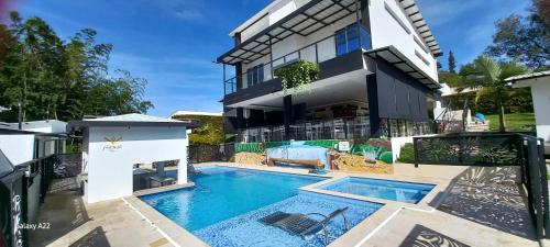 an image of a house with a swimming pool at Hotel y Cabañas Parinzzi in Guatapé