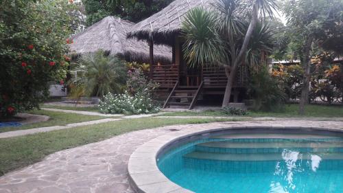 a swimming pool in front of a house at Si Pitung Village in Gili Air
