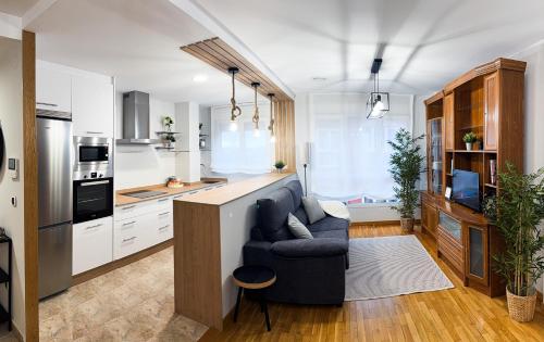 a living room with a couch and a kitchen at San Marcos in Ribadeo