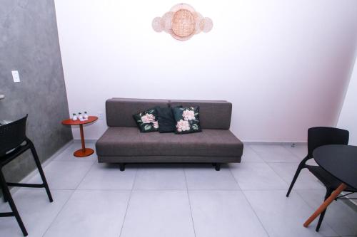 a couch with pillows on it in a room at LOFT PAJUMAR 1 ANDAR 300mt PRAIA PAJUCARA in Maceió