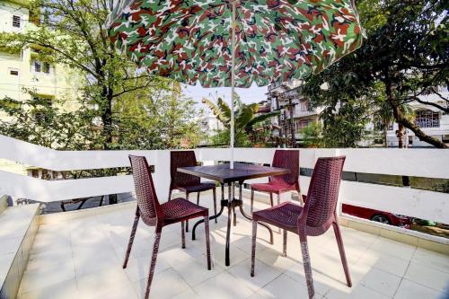 a table and chairs under an umbrella on a patio at Hotel O The Dove Villa in Dispur