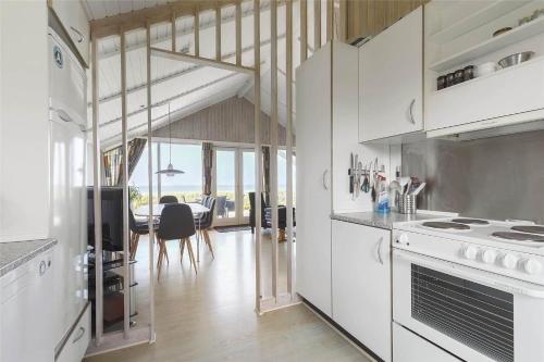 a kitchen with white appliances and a dining room at 17701-Follenslev-Middelvej-2 in Føllenslev
