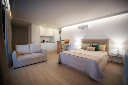Un dormitorio con una cama y una silla y una cocina. en GILS Experience, en Ribeira Grande