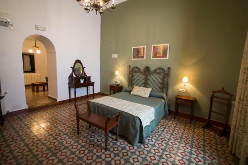 a bedroom with a bed and a chair in a room at Hospedería Real Casona la Beltraneja in Belmonte