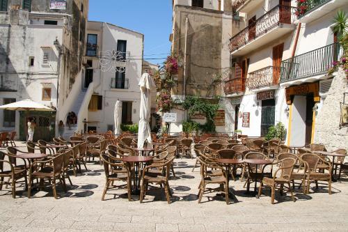 an outdoor patio with tables and chairs and an umbrella at Hotel Corallo Sperlonga in Sperlonga