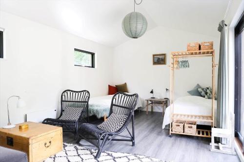 a bedroom with a bed and two chairs and a mirror at 10001-Nykobing-Sj-Strandlodsvej-3 in Nakke