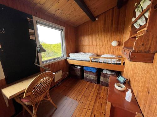 a small room with a bed and a desk and a window at 15507-Farevejle-Mimershoj-2 in Fårevejle