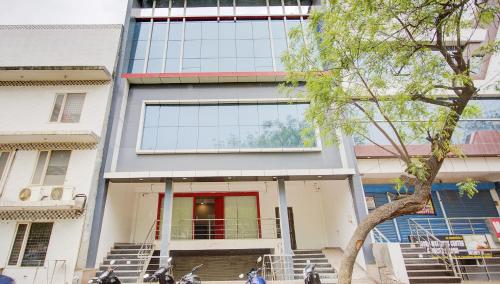 a building with a red door and a tree at Super Townhouse Townhouse Atal Chowk Indirapuram Ghaziabad in Ghaziabad