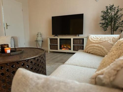 a living room with a tv and a fireplace at Holiday apartment in Teltow with barbecue in Teltow