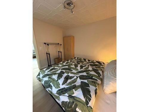 a bedroom with a bed with a leafy comforter at Holiday apartment in Teltow with barbecue in Teltow