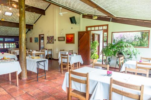 een eetkamer met witte tafels en stoelen bij Pousada Chão da Serra in Serra do Cipo