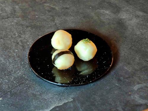 a black plate with some food on a table at 層雲峡温泉 ホテル雲井 in Kamikawa