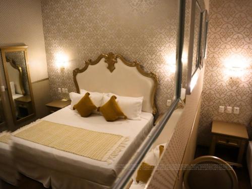 a small bedroom with a bed with yellow pillows at Hotel Embajada in San Luis Potosí