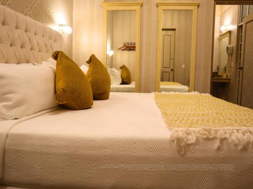 a bed with two yellow pillows on top of it at Hotel Embajada in San Luis Potosí