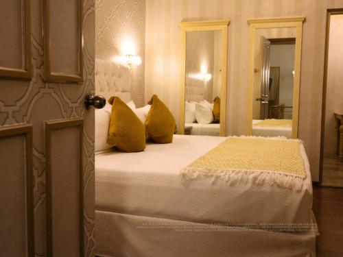 a bedroom with a bed with yellow pillows at Hotel Embajada in San Luis Potosí