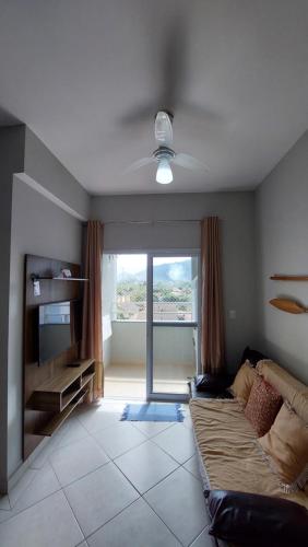 un salon avec un canapé et un ventilateur de plafond dans l'établissement Ubatuba Praia do Itagua Apto Espetacular Completo inteiro, à Ubatuba