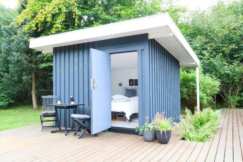 a blue shed with a bed in a bedroom at 13373-Asnaes-Radyrvej-24 in Asnæs