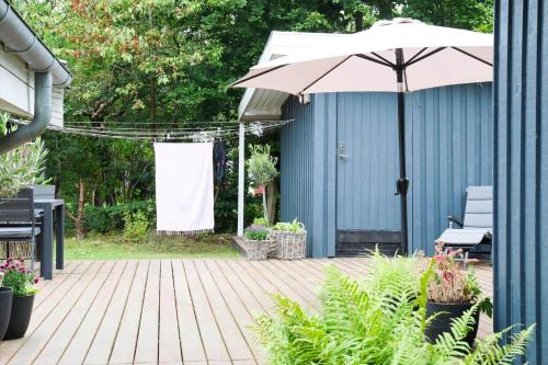 a patio with an umbrella next to a blue building at 13373-Asnaes-Radyrvej-24 in Asnæs