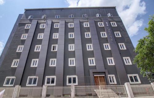 a tall grey building with white windows at Super Townhouse RCC Majestic 397 LB Nagar in Hyderabad