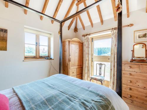a bedroom with a bed and a window at Coblye Barn in Brightling