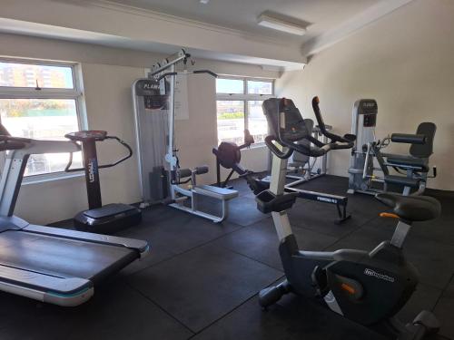 a gym with several tread machines in a room at Top of the Mark in Gold Coast
