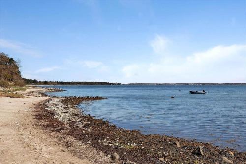 a boat in the water next to a beach at 10064-Rorvig-Skansehagevej-12 in Rørvig