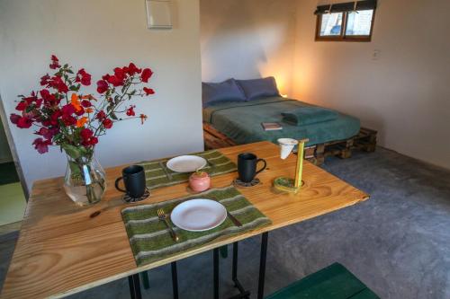 a room with a table with flowers and a bed at Vista do Sincorá in Ibicoara