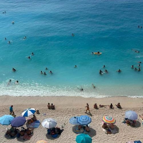 a group of people in the water at the beach at Katsenos studios in Nikiana