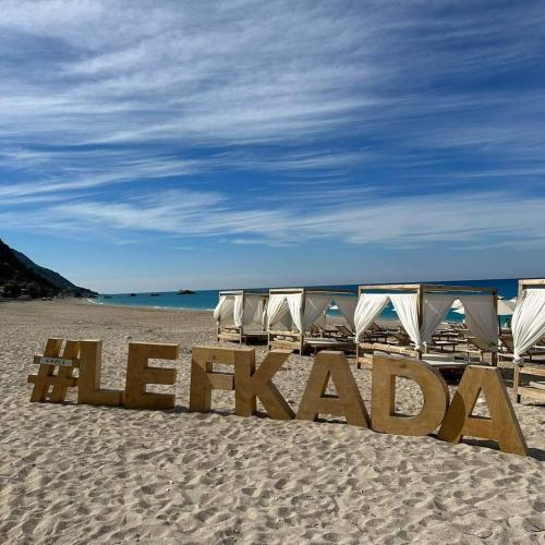 a group of beach chairs and a sign on the beach at Katsenos studios in Nikiana