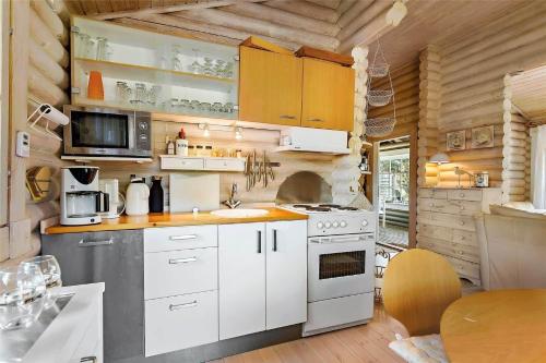 a kitchen with white cabinets and a stove at 10006-Rorvig-Hojsandsparken-3 in Rørvig