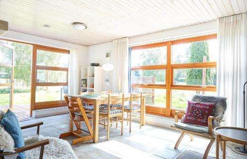 a dining room with a table and chairs and windows at 11862-Nykobing-Sj-Hojgardsvej-4 in Klint
