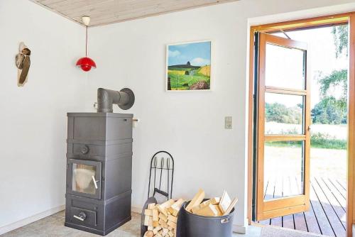 a wood stove in a room with a window at 11862-Nykobing-Sj-Hojgardsvej-4 in Klint