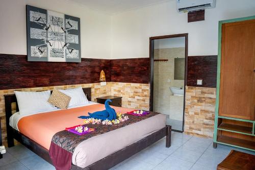 a bedroom with a bed with a dinosaur on it at The Canda Hotel in Nusa Lembongan