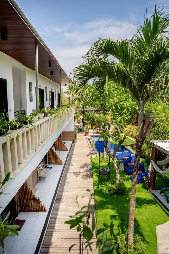 a balcony of a hotel with chairs and palm trees at The Canda Hotel in Nusa Lembongan