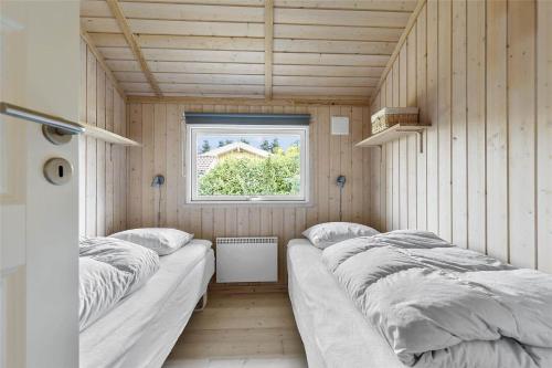 a room with three beds in it with a window at 13329-Asnaes-Leifavej-Vestre-11 in Asnæs