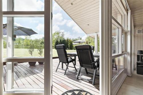 a screened in porch with a table and chairs at 13329-Asnaes-Leifavej-Vestre-11 in Asnæs